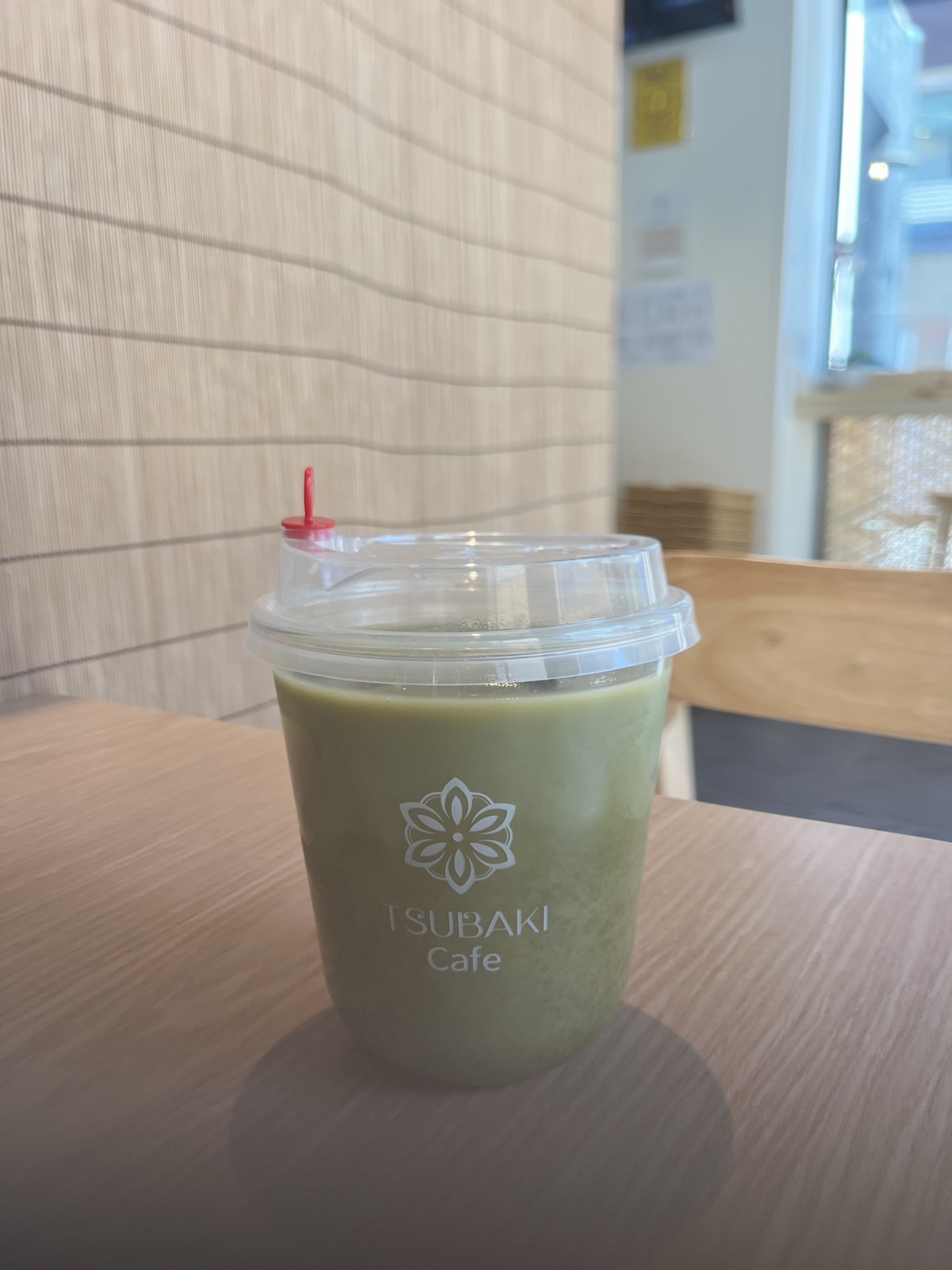 Iced matcha latte in a Tsubaki Cafe cup